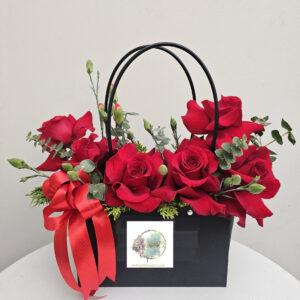 Cartera de rosas rojas, que proyecta pasión y sofisticación. La combinación de las flores vibrantes con la base negra y  un contraste clásico y lujoso.