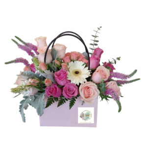 Hermoso arreglo floral en cartera rosada, en rosas y follaje de tonos rosados.